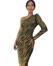A woman in a Nik Spruill Escape One Shoulder Crystal Dress in gold and black.