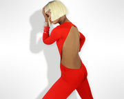 Side view of a woman wearing a backless red jumpsuit with cut out  by Nik Spruill