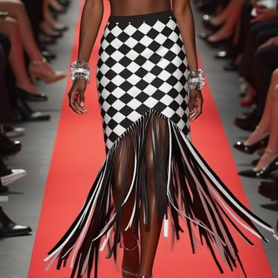 A model struts down the runway in Nik Spruill's CHECKMATE CROCHET FRINGE SKIRT, featuring a sophisticated black and white color block design with playful fringes.