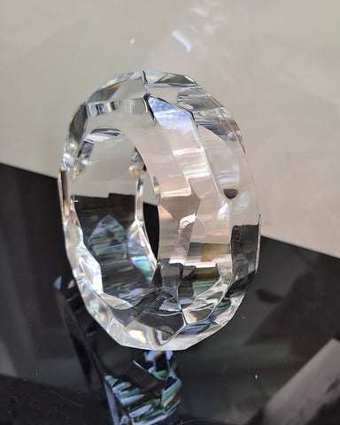 Close-up of the Nik Spruill Angles Lucite Bangle Bracelet displayed on a reflective black and white surface, showcasing its unique accessory appeal.