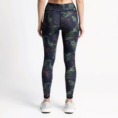 Person wearing dark blue leggings with a multicolor abstract pattern on a white background