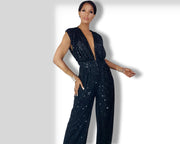A woman in a Nik Spruill Glitz Sequined Jumpsuit - Black posing for a picture.