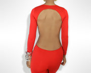 Back view of a woman wearing a red backless jumpsuit by Nik Spruill