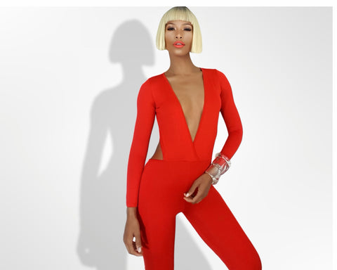 A woman is posing in a Nik Spruill Jade cutout backless jumpsuit - red.
