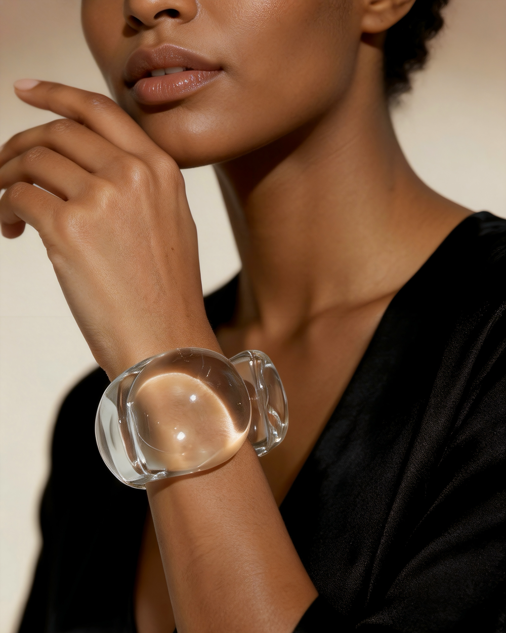 Clear lucite cuff bracelet on model wrist with sunlight reflecting through transparent acrylic, creating a bold statement jewelry look