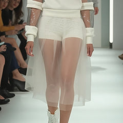 A model walks the runway wearing Nik Spruill's white HARMONY HALO SHORT, featuring a 3D mesh skirt, paired with sporty shoes.