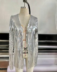 A mannequin wears the Nik Spruill SIVA STEEL SEQUIN FRINGE JACKET, its silver sparkle highlighted by long sleeves and playful fringe, set against a studio backdrop.