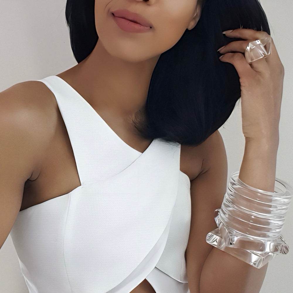 A person posing in a white sleeveless top, wearing several clear, chunky bracelets and an ITGA ring by Nik Spruill, hand polished for that perfect shine.