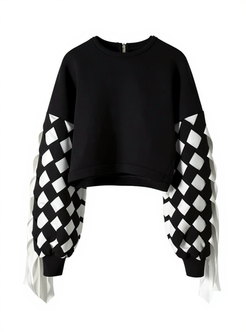 The Stitch Crochet Fringed Top by Nik Spruill is a striking black sweatshirt with unique ribbon interlock white and black sleeves. The ribbon hangs like fringe creating a unique look. Front view