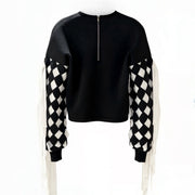 Black sweater with checkered sleeves on a white background
