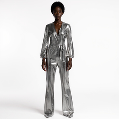 Person wearing a silver metallic jumpsuit on a white background