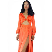 Woman wearing an orange dress with a cutout design on a white background