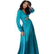 Woman wearing a teal long-sleeve dress on a white background