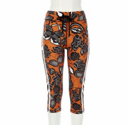 Orange leggings with black floral pattern on a white background