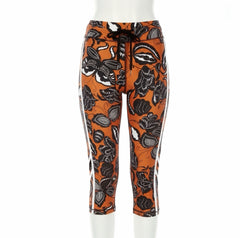 Orange leggings with black floral pattern on a white background