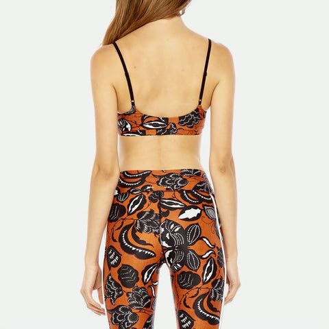 Person wearing a floral-patterned top and leggings on a white background