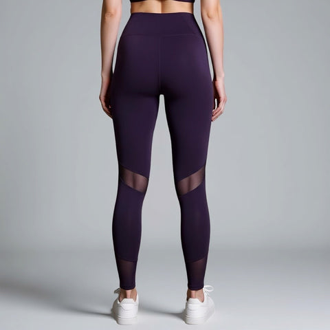 Purple leggings with mesh panels worn by a person on a gray background