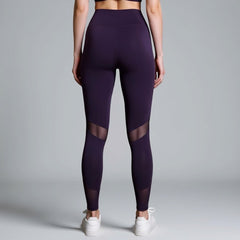 Purple leggings with mesh panels worn by a person on a gray background