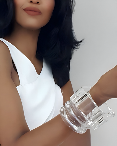 A person with shoulder-length dark hair wears a white sleeveless top and Nik Spruill's hand-carved lucite bracelets, ICEBERG, on their wrist, holding up their arm.
