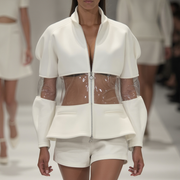 A runway model showcases Nik Spruill's OCEAN 7 JACKET, featuring transparent panels paired with white shorts, capturing the Ocean 7 collection's essence as other models fade into the background.