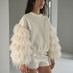 Model wearing an AIR SPACE OFF WHITE TOP by Nik Spruill, featuring a high neck and feathered sleeves, paired with sleek leather bottoms.