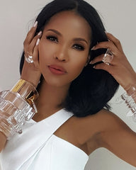 A woman in a white dress holding a glass of Nik Spruill's IMAK wine.