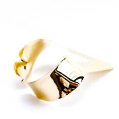 A NANISCA - GOLD ring sitting on top of a white surface, designed by Nik Spruill.