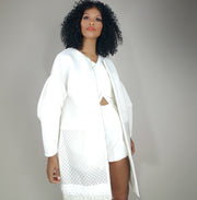 full image of model in a white neoprene bell sleeve coat with clear mesh detailing
