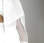 A woman wearing a white dress and a Nik Spruill Conscious Jacket.