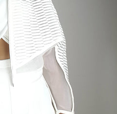 A woman wearing a white dress and a Nik Spruill Conscious Jacket.