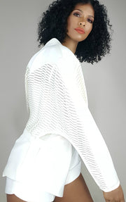 a woman wearing a Nik Spruill CONSCIOUS JACKET and shorts.