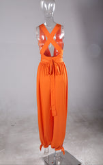 A Nik Spruill mannequin wearing The fearless one deep plunge backless jumpsuit - orange with a bow tie.