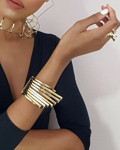 A woman wearing a HERU black dress and Nik Spruill gold jewelry.