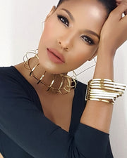 a woman wearing Nik Spruill's HERU in a black top and gold bracelets.