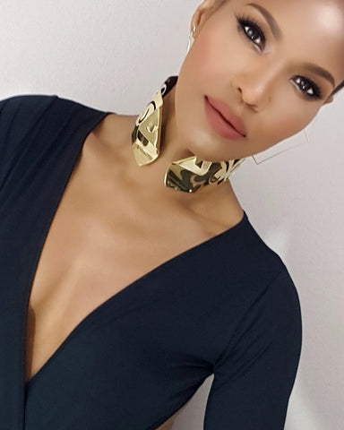 A woman wearing a Nzinga dress and Nik Spruill gold choker.