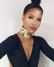 A black woman wearing a Nzinga gold choker from the Nik Spruill brand.