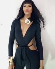 A woman in a black outfit with a Nik Spruill AMENZA gold necklace.