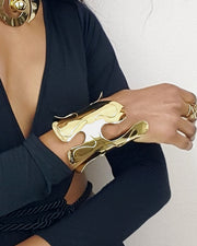 A woman wearing an OSHUN black dress and Nik Spruill gold jewelry.