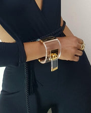 A woman wearing a black top and a Nik Spruill DROP - GOLD bracelet.