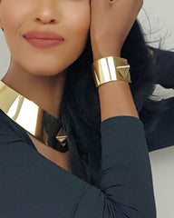 A woman in a black top with a gold Nik Spruill ISIS CUFF collar.