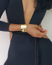 A woman wearing a Nik Spruill ISIS CUFF bracelet and a black dress.