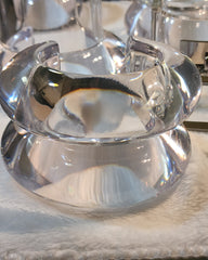 a glass bowl with a spoon in it on a table.