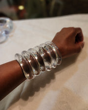 A close up of a person wearing a Nik Spruill Waves Cuff.