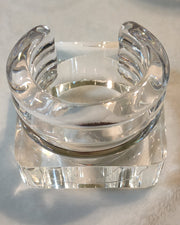 An ICEBERG clear glass candle holder from Nik Spruill sitting on top of a table.