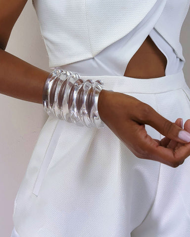 A close up of a person wearing a white dress and the Nik Spruill WAVES CUFF.