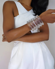 A woman wearing a white dress and a Nik Spruill WAVES CUFF bracelet.