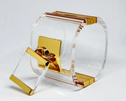 A pair of Nik Spruill DROP - GOLD glasses sitting on top of a glass holder.