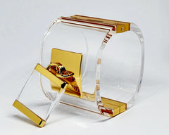 A pair of Nik Spruill DROP - GOLD glasses sitting on top of a glass holder.