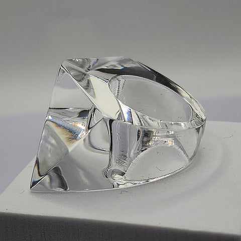 A clear IMAK ring sitting on top of a white Nik Spruill box.