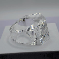 A clear ZENUS ring sitting on top of a white Nik Spruill box.